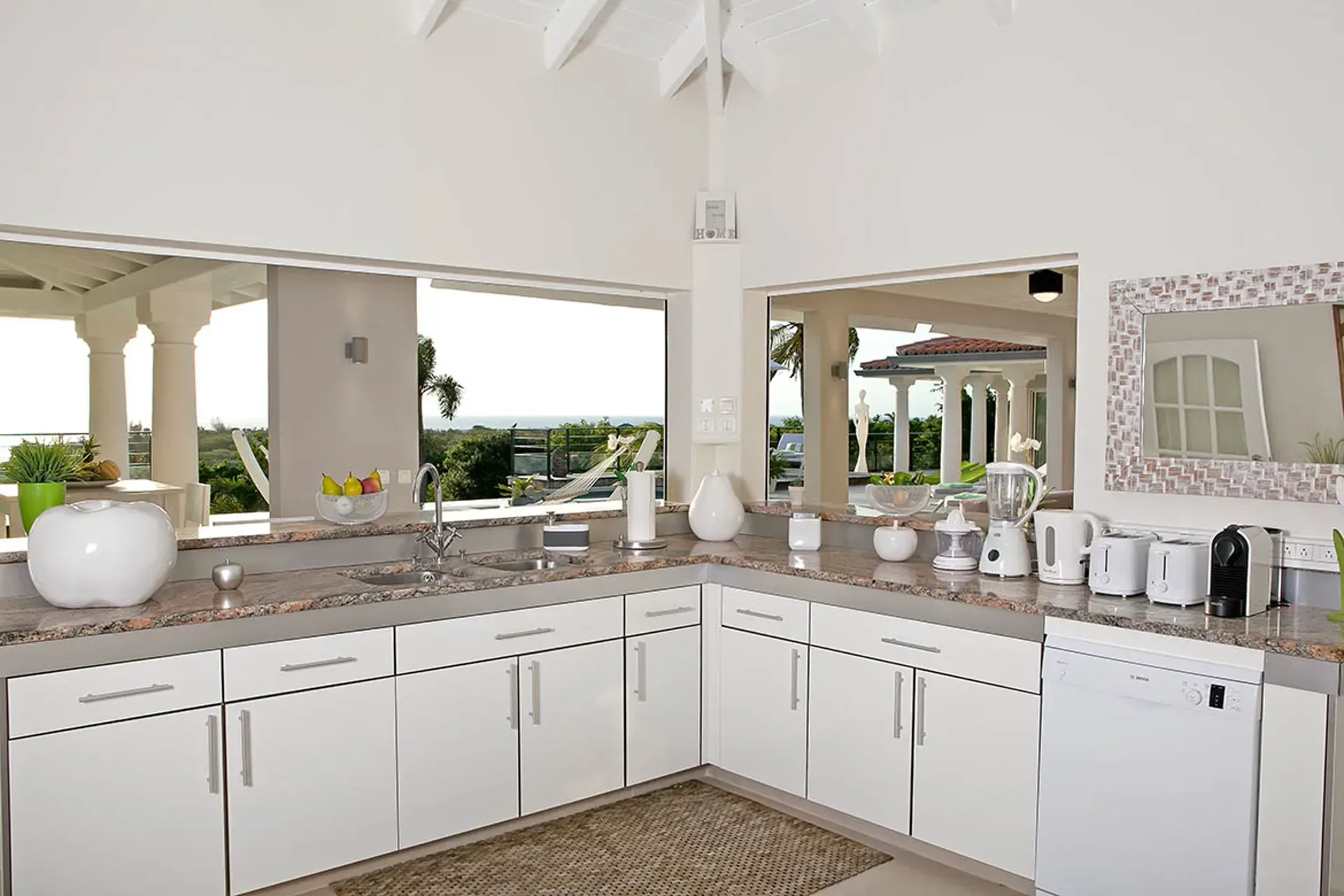 Modern kitchen with granite countertops and ocean views.