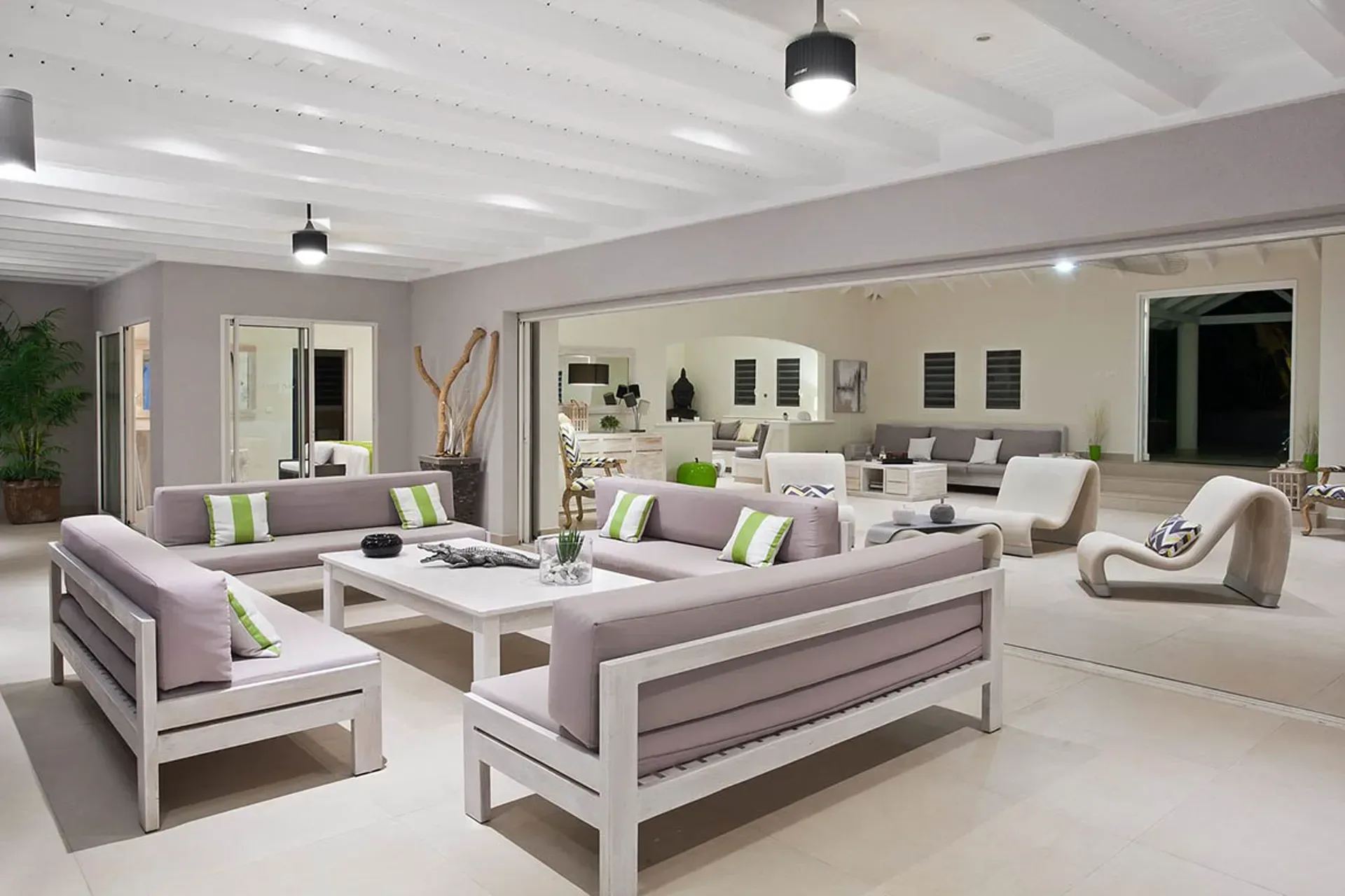 Living room flowing to covered terrace with ocean views.