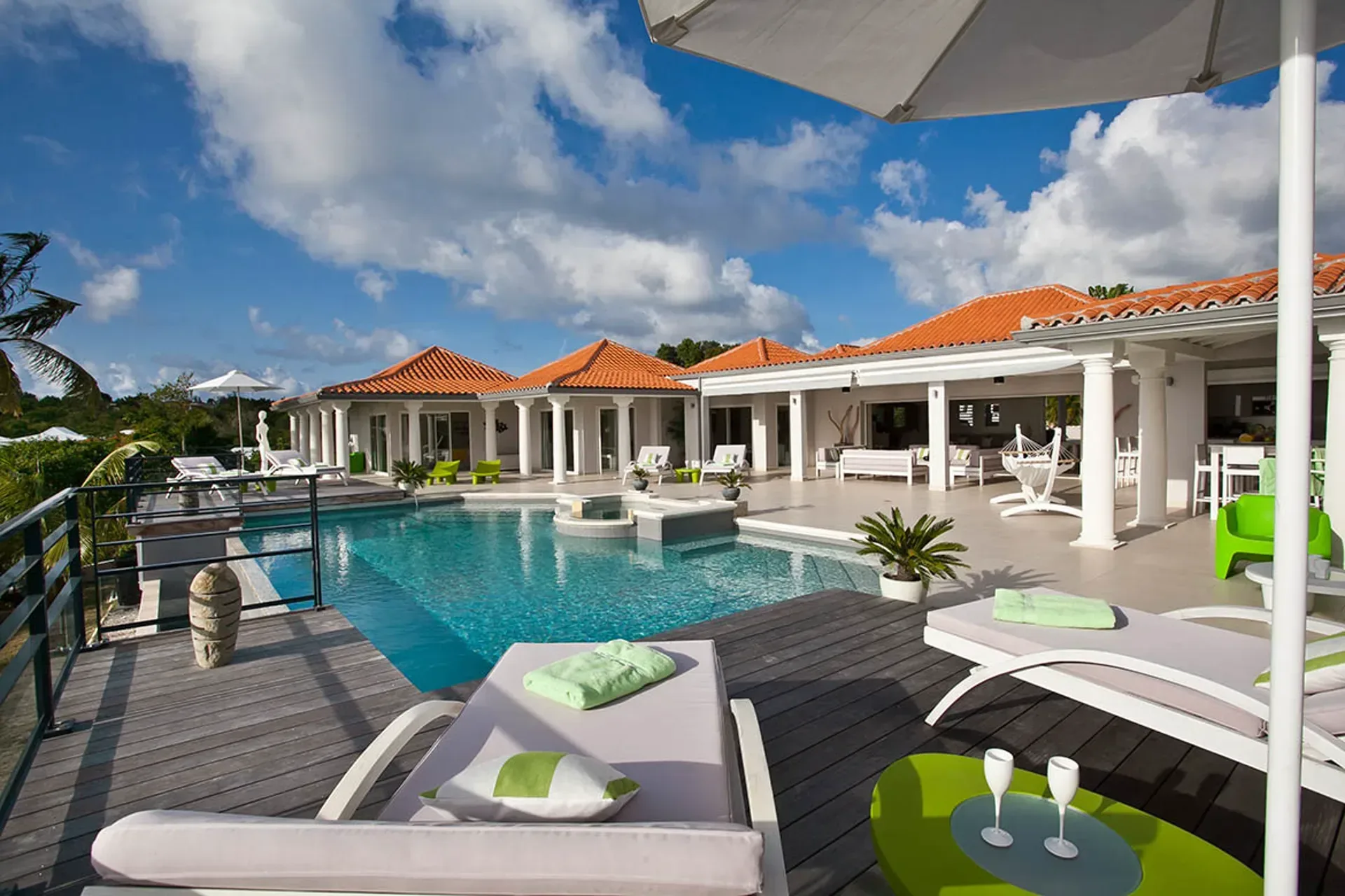 Pool with loungers and Mediterranean villa backdrop.