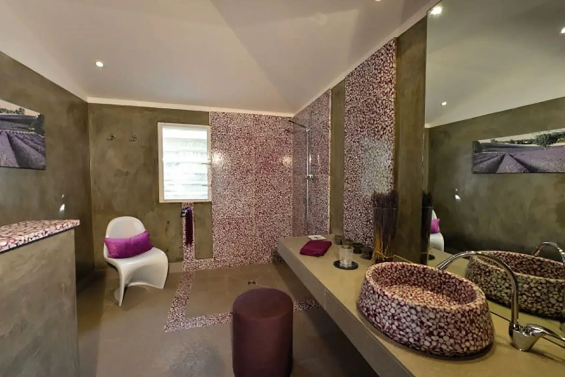 An artistic bathroom featuring purple mosaic tilework, vessel sink, and modern concrete vanity.