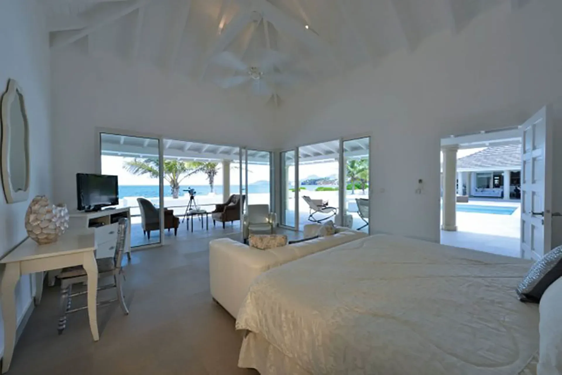 Wake up to ocean views from your master suite with vaulted ceilings, white sofa, and direct terrace access.