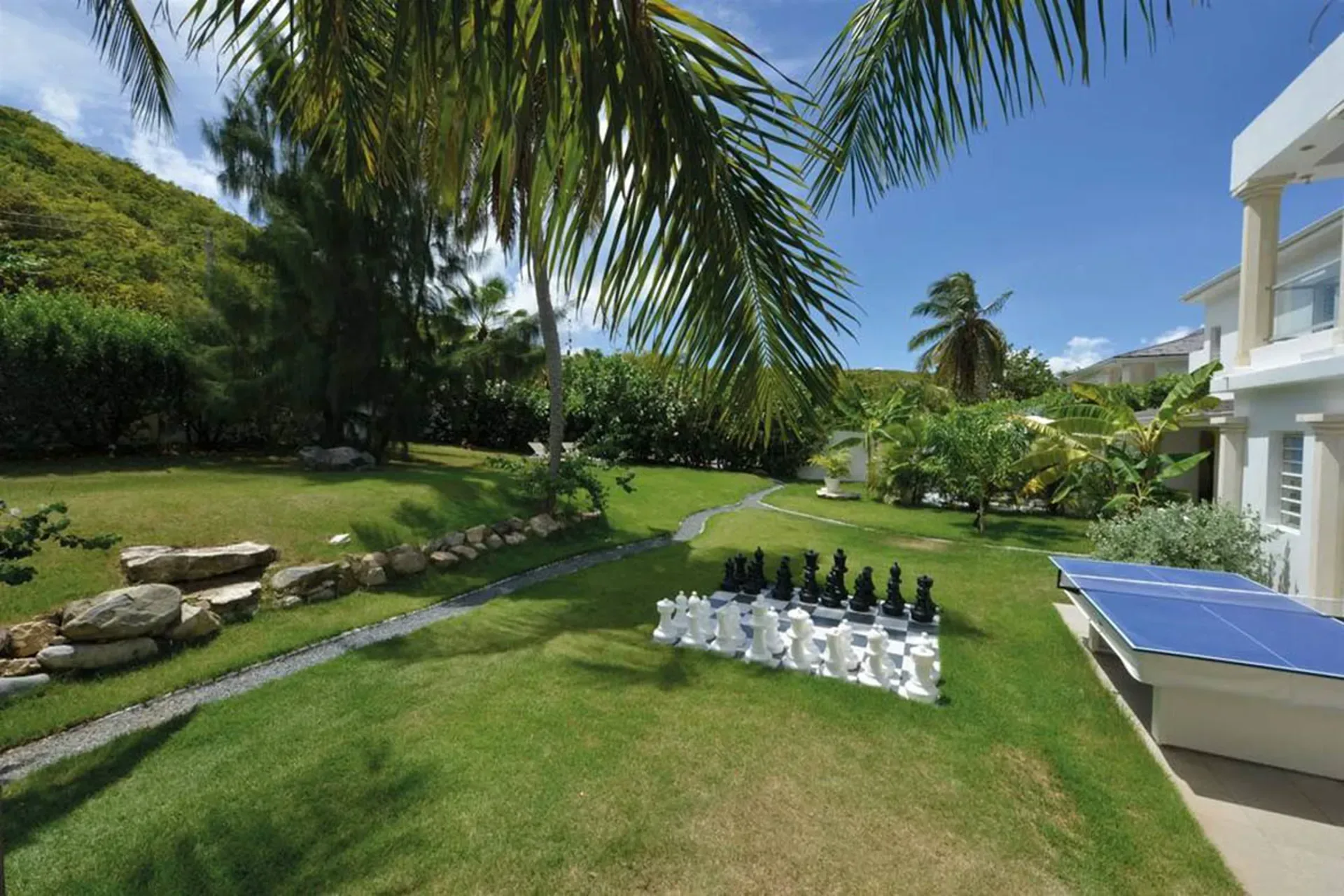 Enjoy outdoor recreation with life-sized chess, ping-pong, and lush tropical gardens at your private estate.