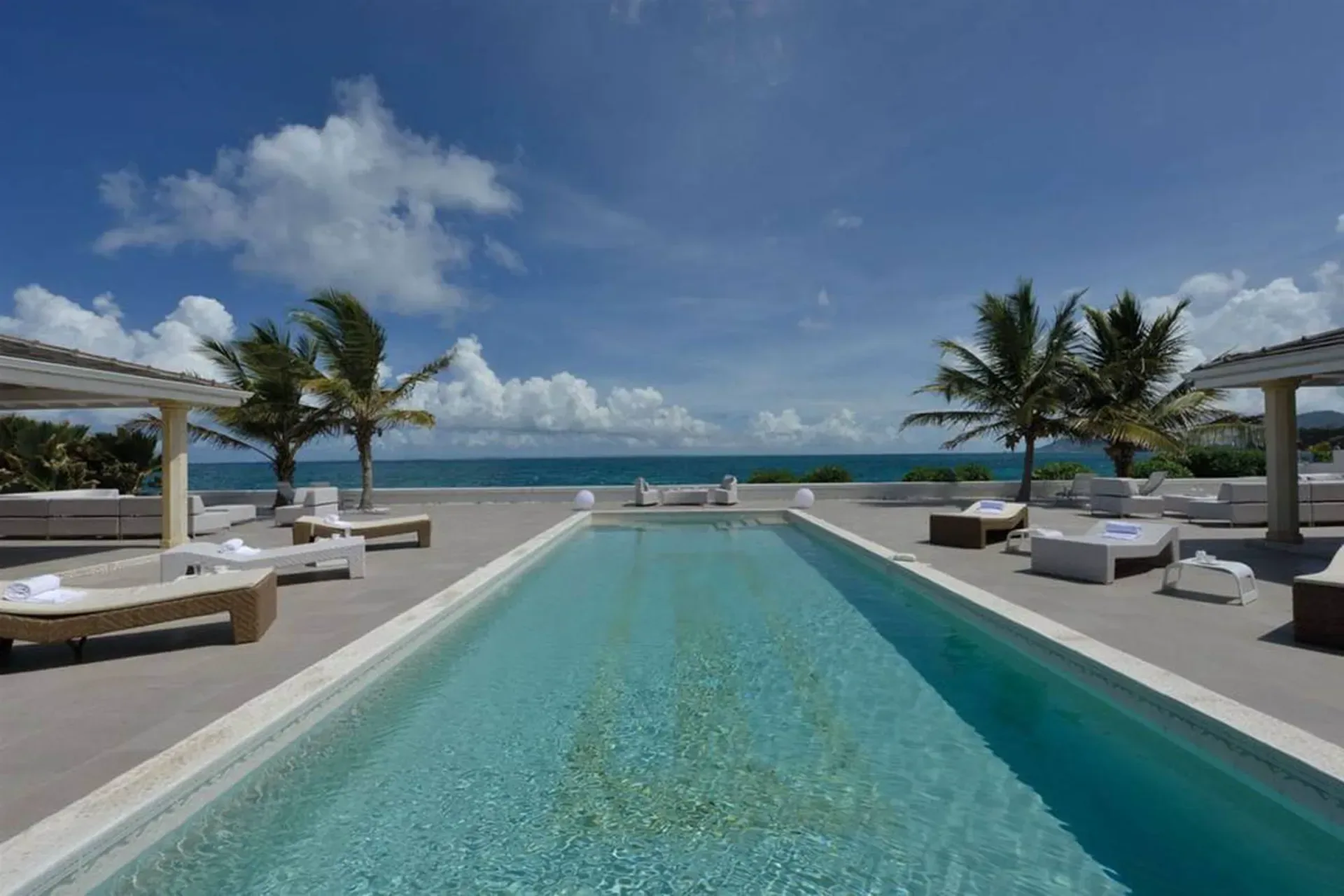 Swim laps in your expansive infinity pool surrounded by palm trees and panoramic ocean views.