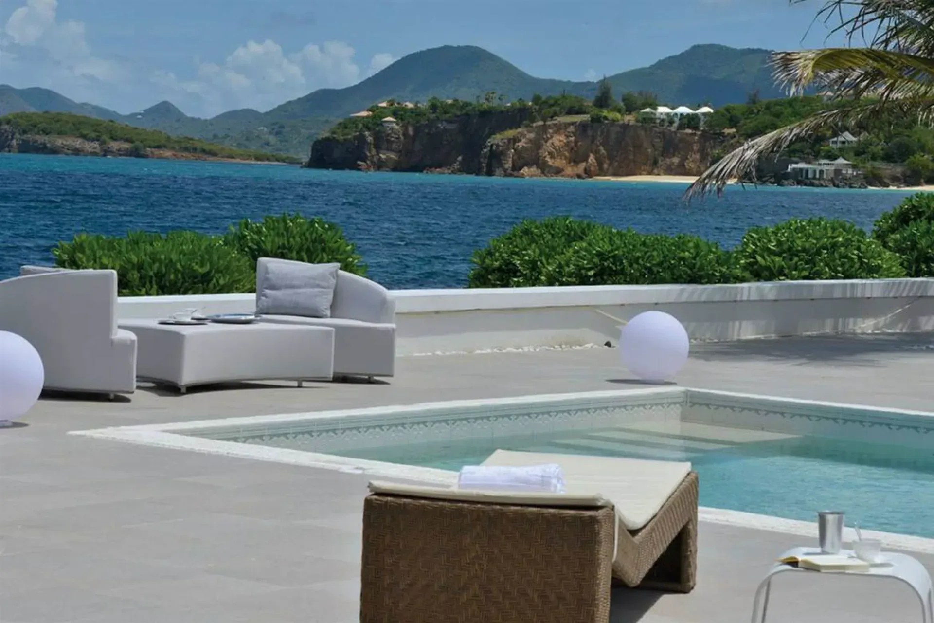 Lounge in style with modern white furniture, sculptural lighting, and sweeping ocean views from your pool terrace.