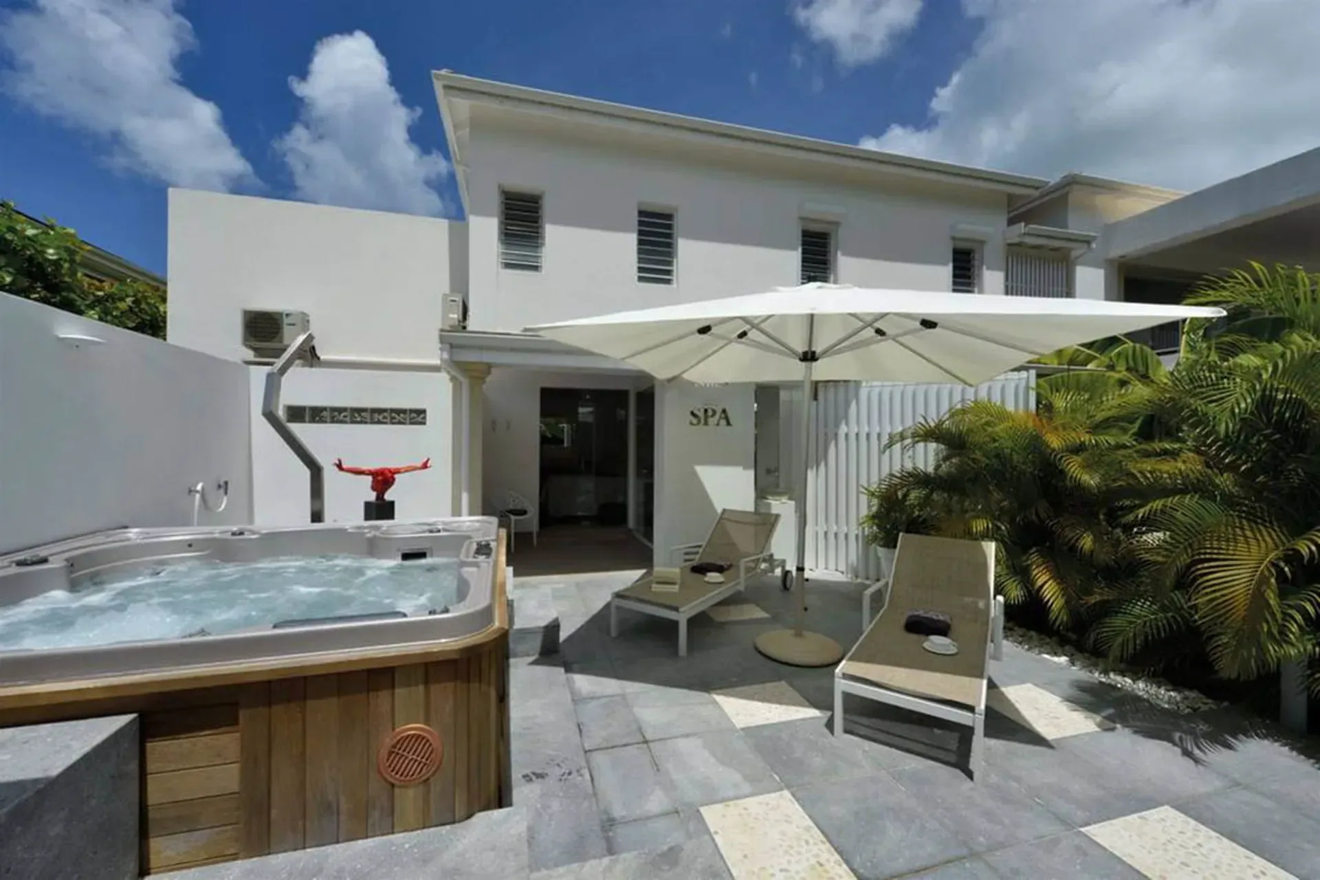 Soak in your private hot tub surrounded by tropical palms with comfortable loungers for the ultimate relaxation.