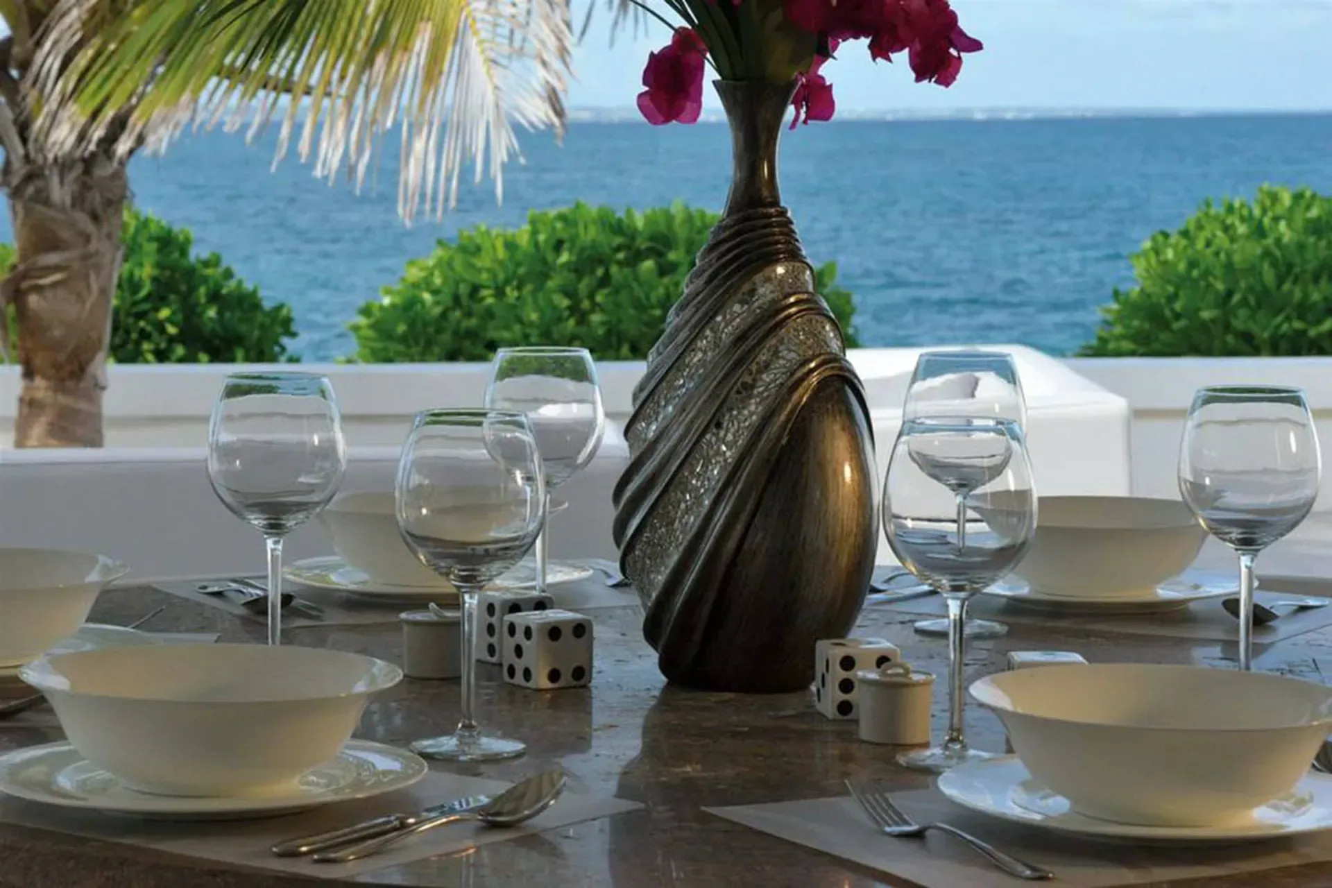 Dine al fresco with elegant table settings, tropical bougainvillea, and panoramic ocean views from your private terrace.