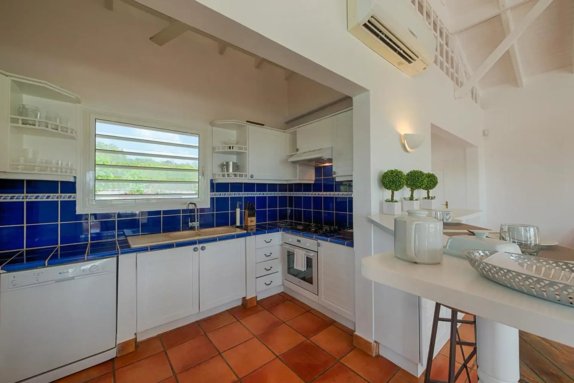 Cook with Caribbean flair in a charming kitchen with terracotta floors.