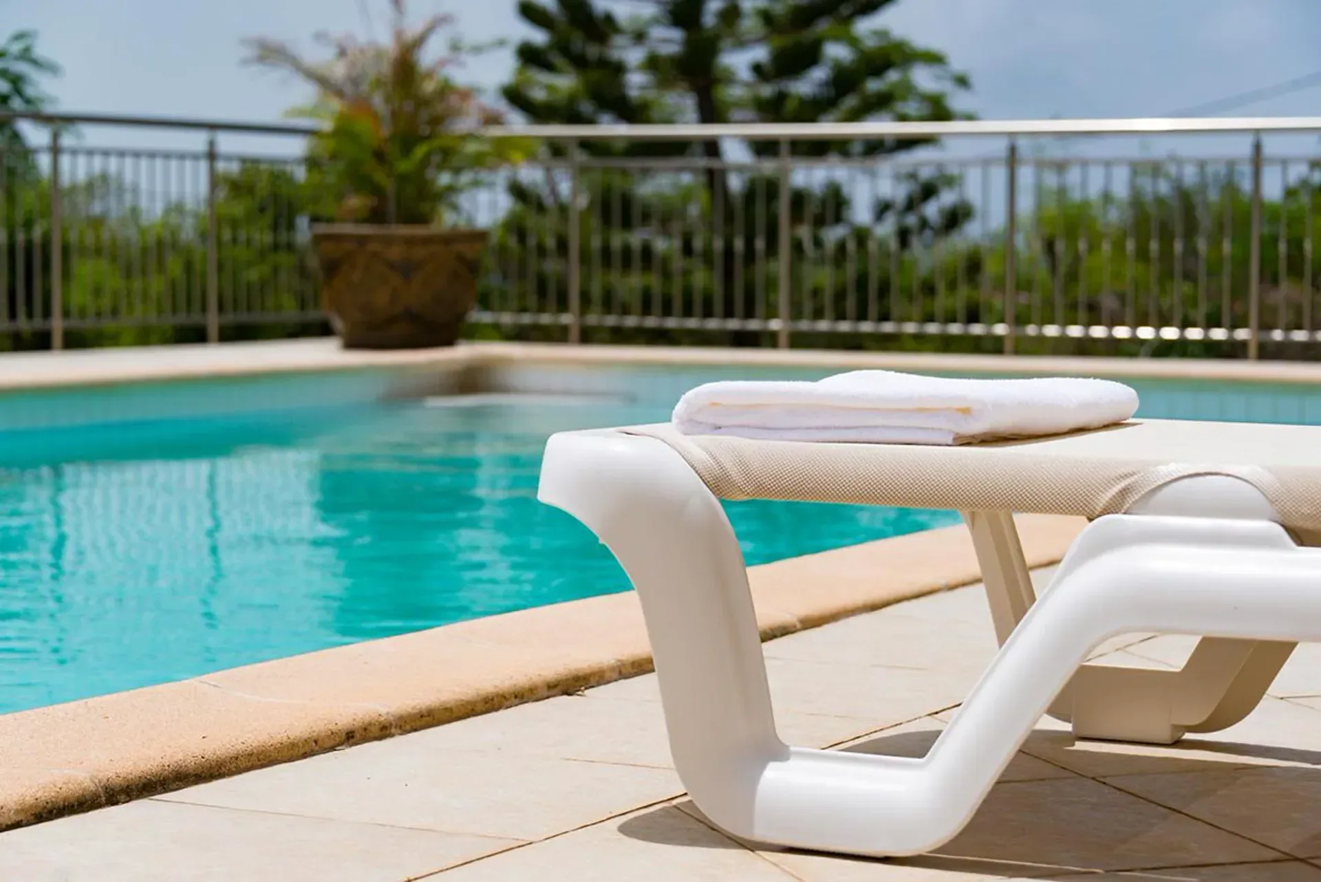 Sink into a comfortable lounge chair by the shimmering turquoise pool.