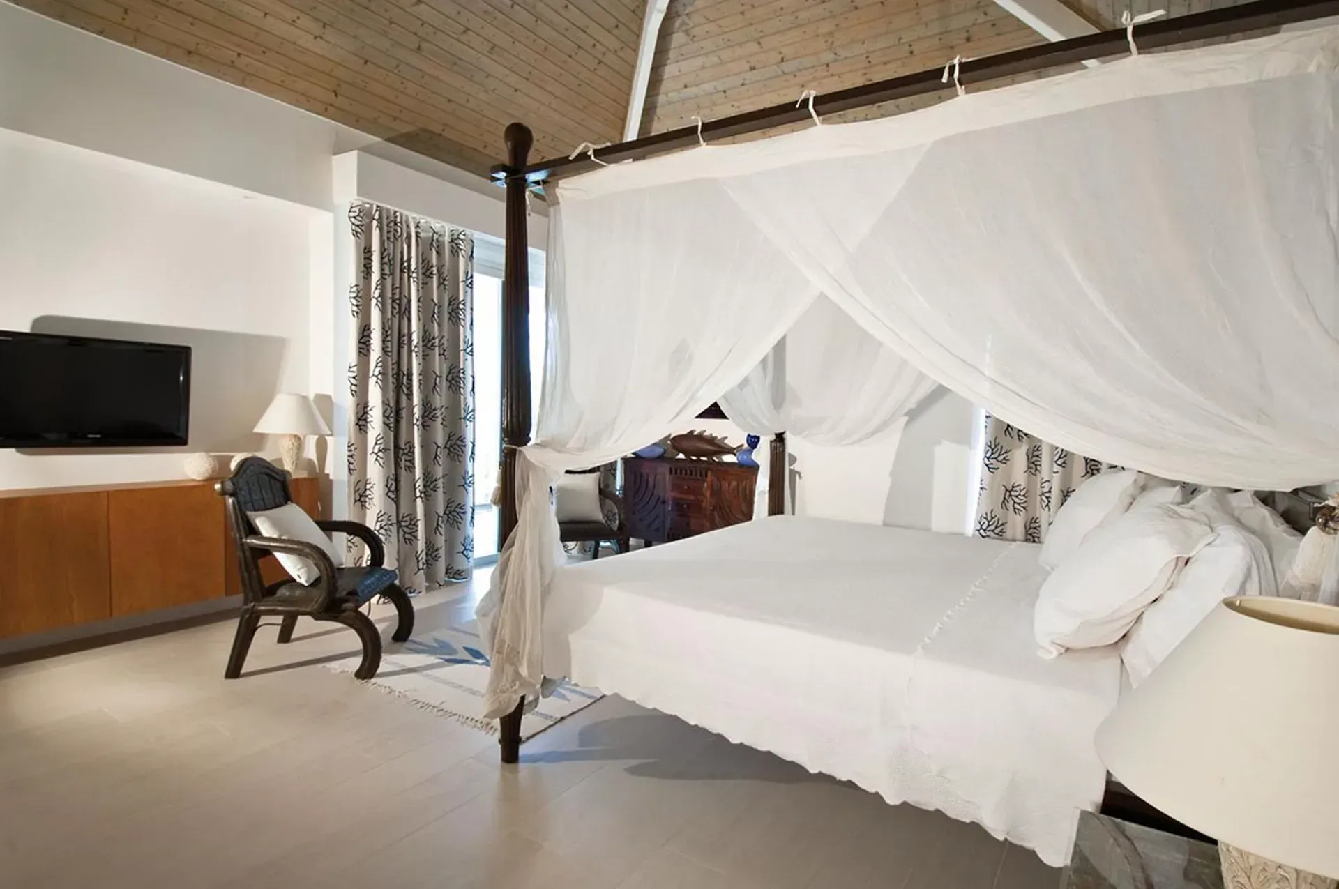 Retreat to elegant luxury with a romantic canopy bed and tropical-chic decor.