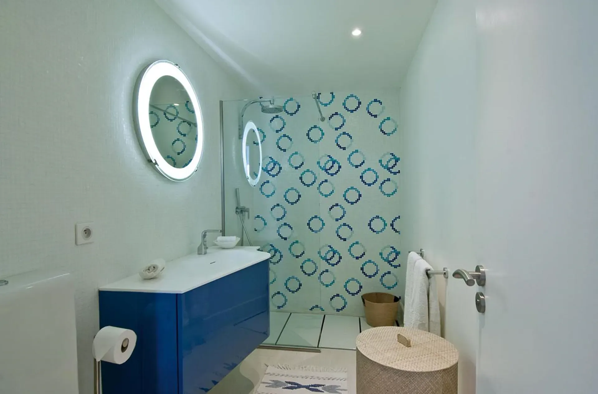 Refresh in stylish modern luxury with a vibrant blue vanity and contemporary walk-in shower.