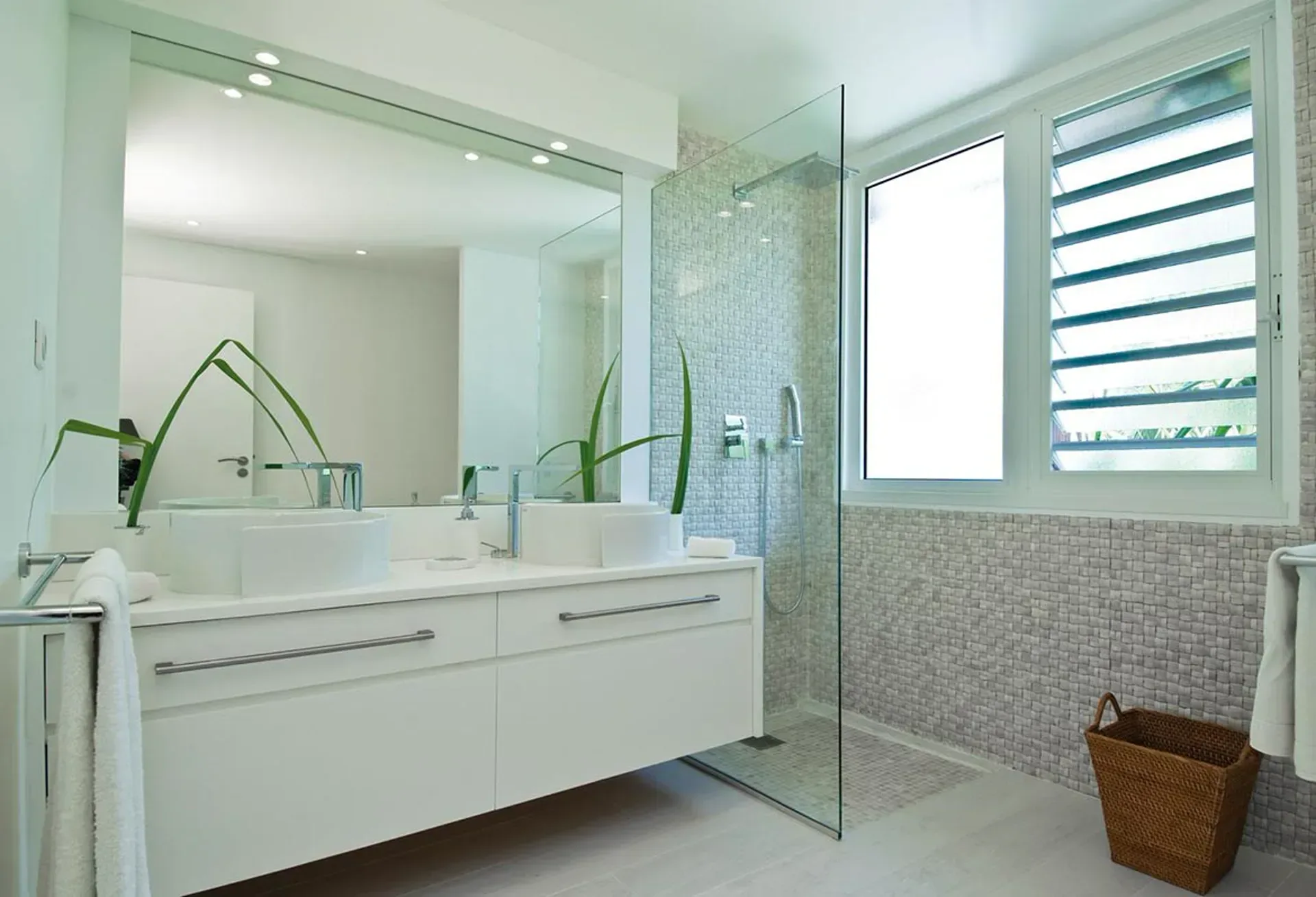 Refresh in a bright spa-inspired bathroom with a sleek double vanity and elegant mosaic tiling.