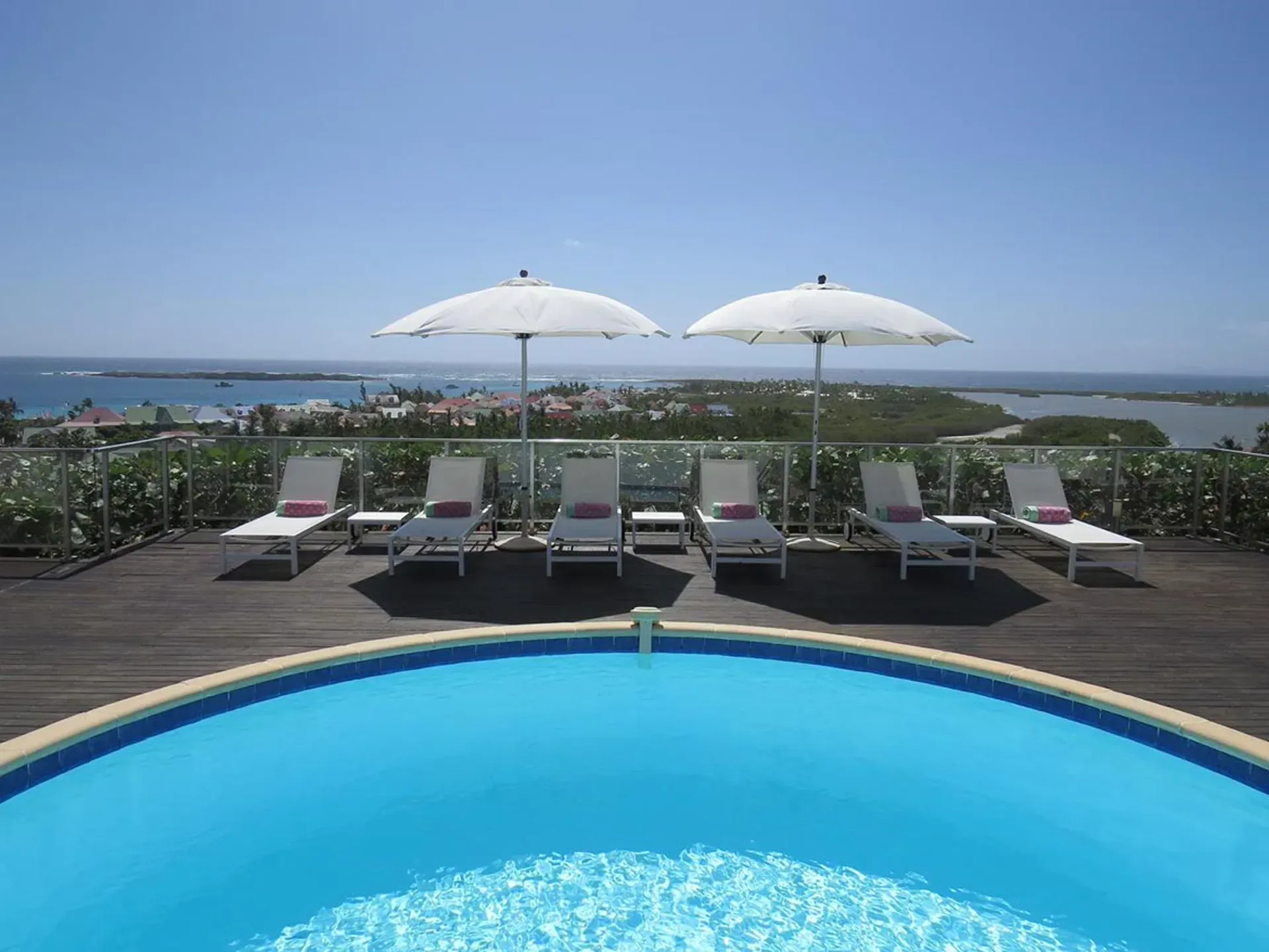 Relax on a stunning pool deck where white loungers and breathtaking ocean views create the perfect Caribbean escape.