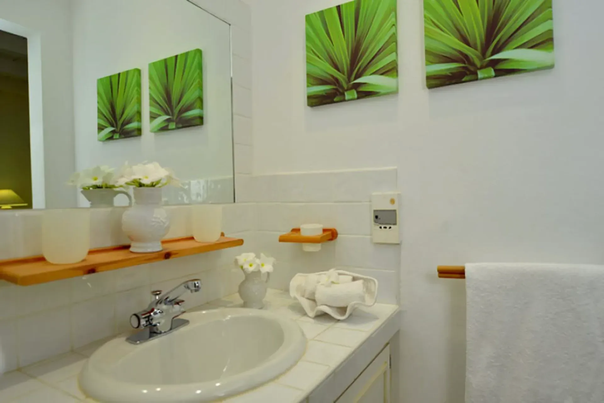 A charming bathroom vanity with botanical art prints, tropical flowers, and classic Caribbean style.